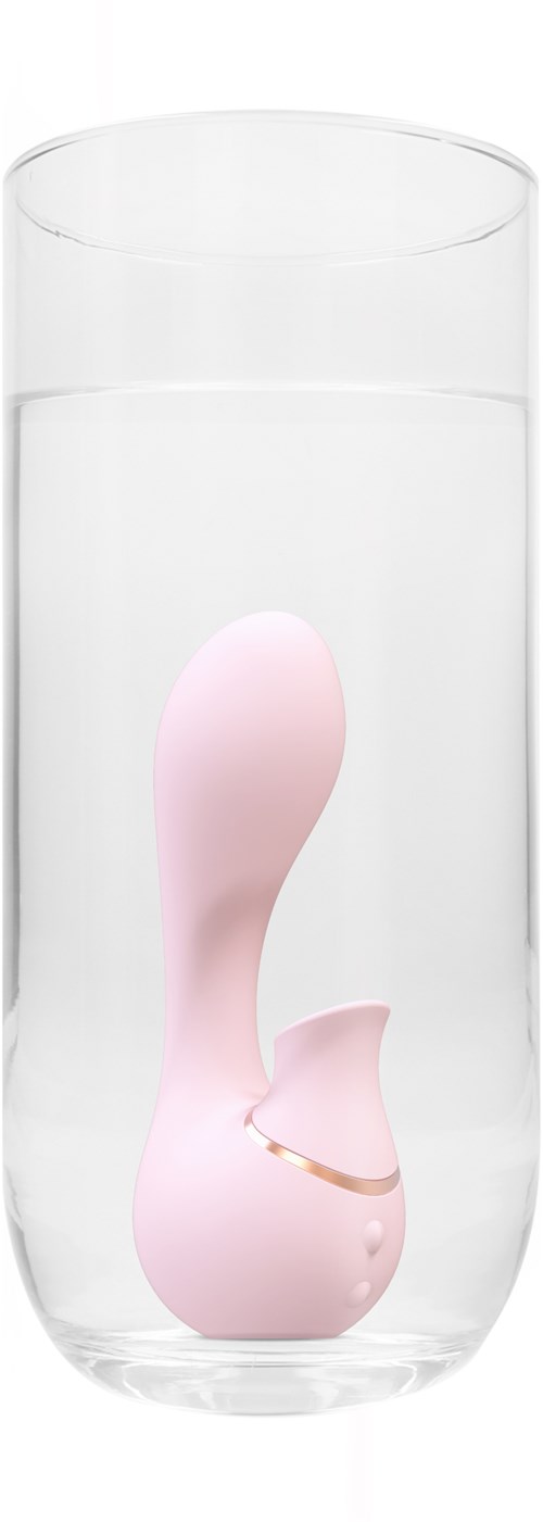 A pink device floats inside a clear glass of water, with a golden ring near the bottom.
