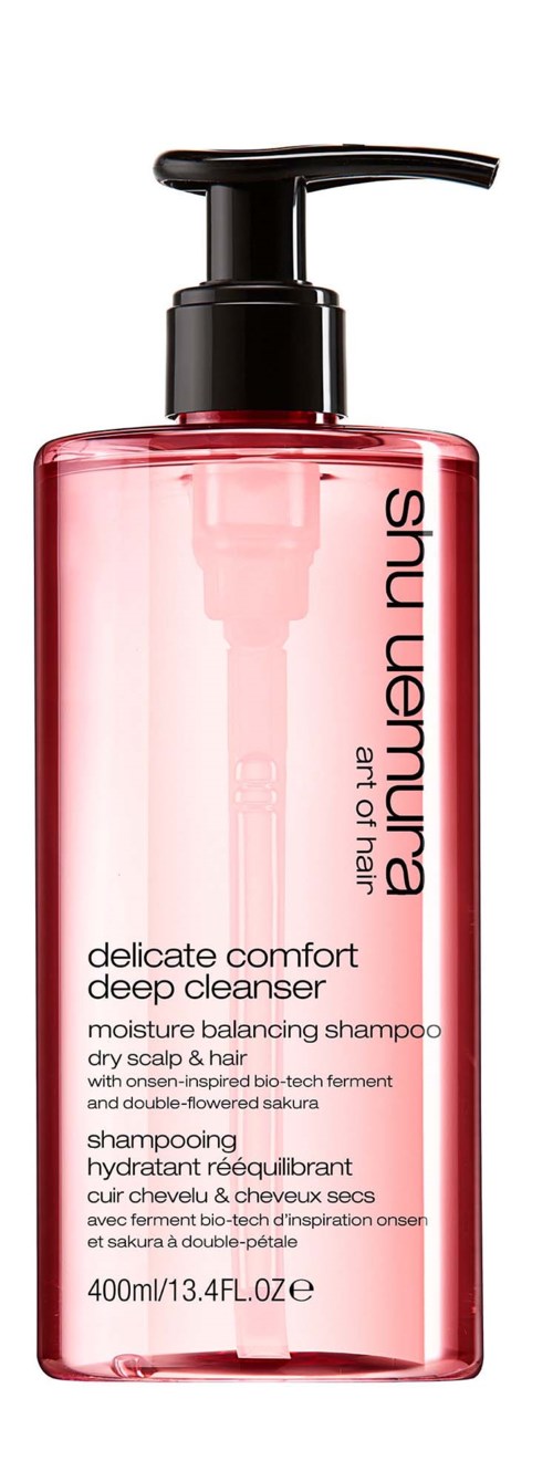 En rosa genomskinlig flaska med en svart pump, märkt 'Shu Uemura Art of Hair'.