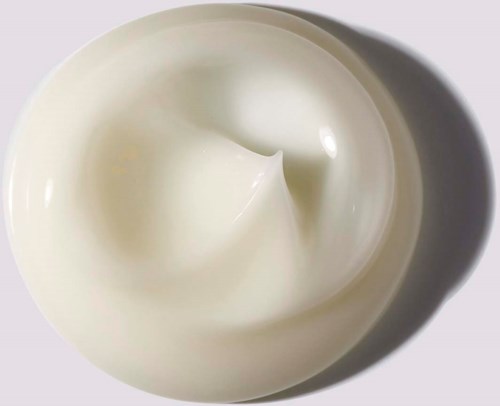 En virvel av vit grädde eller yoghurt i en skål, kastar en skugga på en ljus bakgrund.