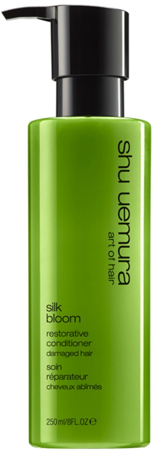 Grön flaska med pump, märkt 'Shu Uemura, silk bloom, reparerande balsam för skadat hår.'