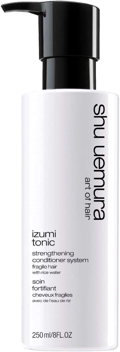 En vit flaska med svart pump, märkt Shu Uemura, innehållande balsam för bräckligt hår. Den är 250 ml.
