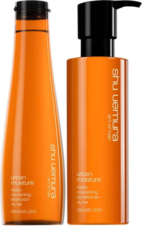 Två orange flaskor, en är schampo och den andra är balsam, båda märkt 'urban moisture' av Shu Uemura.