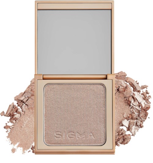Ett öppet makeup-compact med ljusbeige pudder och spegel inuti locket, omgivet av lössnö-puder.