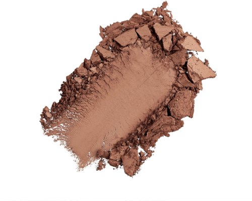 A brown powder is spread out, with some broken pieces around it, on a white background.