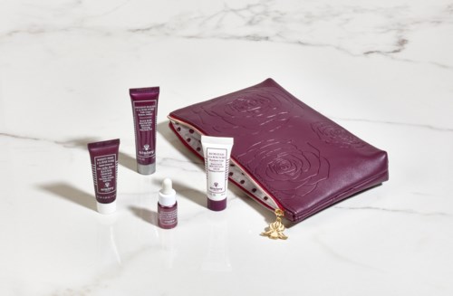 Fyra hudvårdsrör och en lila dragkedjefodral med rosor på en vit yta.