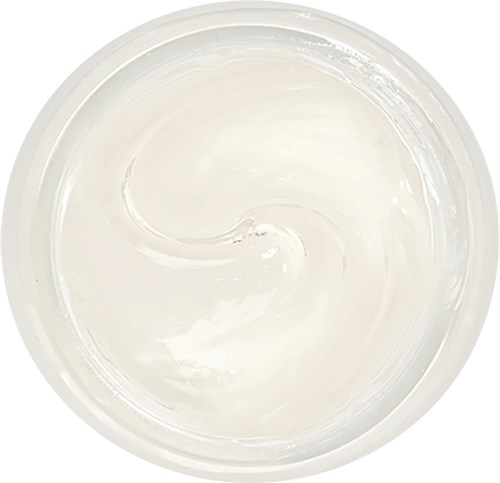 En klar rund skål fylld med slät vit kräm eller lotion, som rör sig försiktigt inuti.