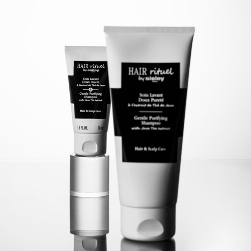 Kaksi mustavalkoista hiustenhoitopulloa, yksi iso ja yksi pieni, etiketeissä mainitaan shampoo ja päänahka.