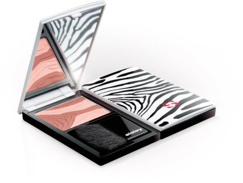 En kompakt sminkuppsättning med zebramönster, innehållande blush, spegel och appliceringsverktyg.