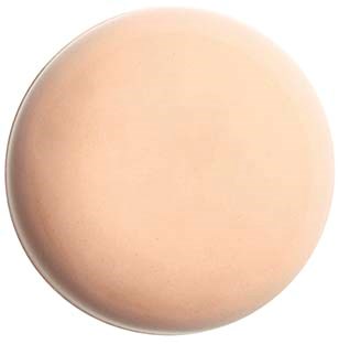 Sileä, pyöreä, beigeväriinen esine, jonka pinta on hieman kiiltävä ja reuna käyrä.
