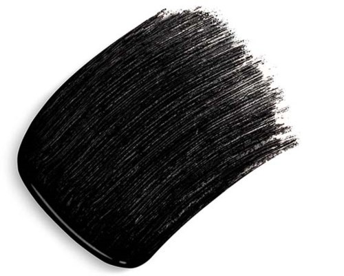 A thick, black makeup brush stroke on a white background, showing texture and bristle details.