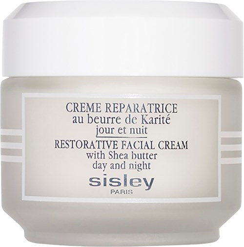 En vit burk innehåller Sisley återställande ansiktskräm med shea smör för dag och natt användning.