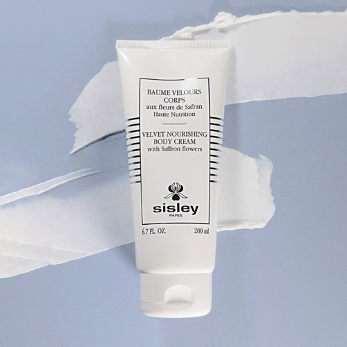 En vit tube med Sisley velvet närande kroppskräm med saffransblommor på en vit bakgrund.
