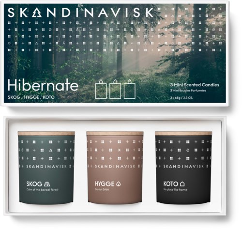 Set van drie kaarsen in verschillende kleuren, gelabeld Skog, Hygge, Koto, met een bos scène op de doos.