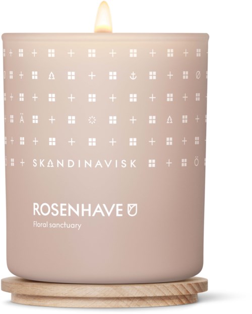 Różowa świeca z płonącym knem, ozdobiona symbolami scandinawskimi, oznaczona jako Rosenhavet.