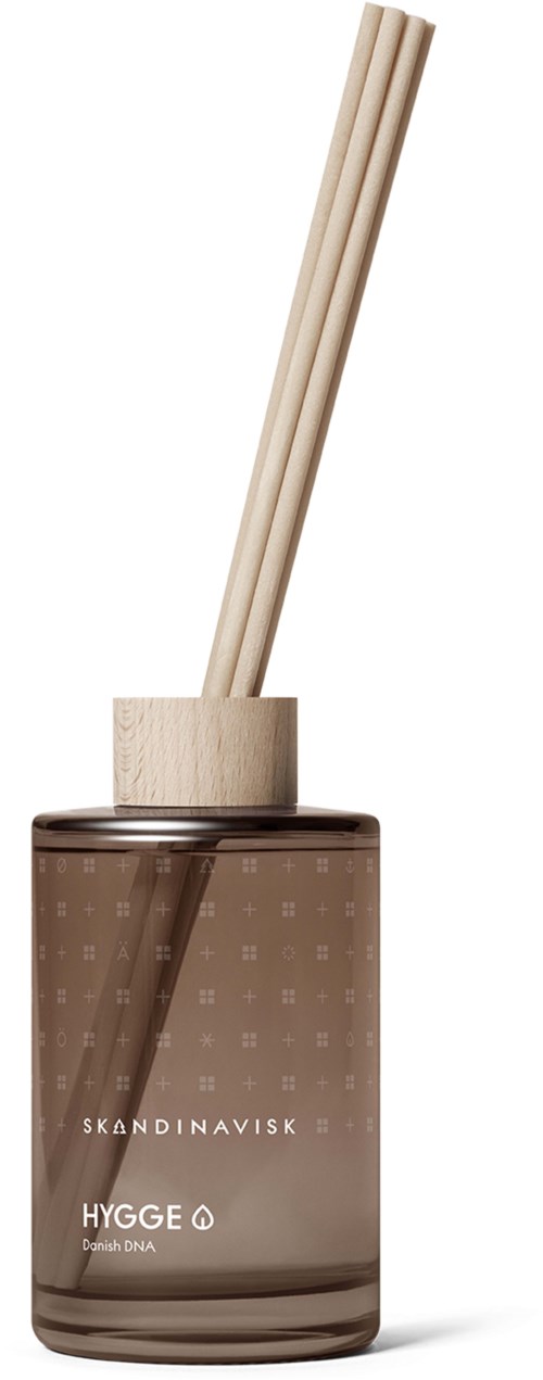 A brown glass container holds wooden sticks, labeled 'Skandinavisk Hygge' and 'Danish DNA' with two sticks inside.