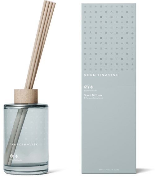 A glass diffuser with wooden sticks in a clear jar, and a light blue box beside it. Both are decorated with small symbols.