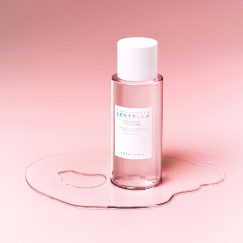 A pink bottle labeled 'Centella' on a pink background, with a puddle of liquid around it.