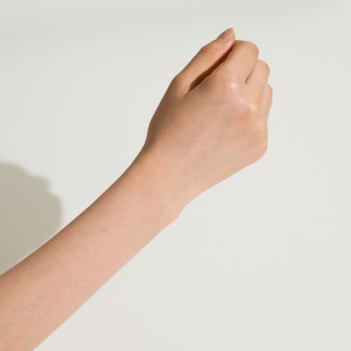 En hand syns med fingrarna slutna, som om den håller eller förbereder att greppa något.