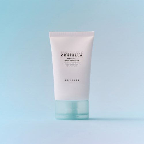En hvid tube med hudplejeprodukt mærket 'Centella Hyalu-Cica Moisture Cream' med blå top på en lyseblå baggrund.
