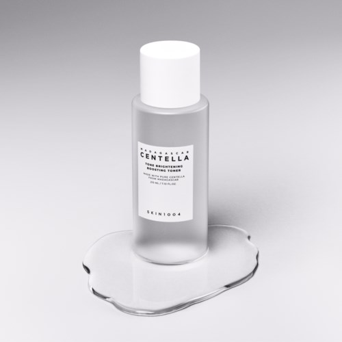 En liten flaske med hvit kork og etikett, som står på en vanndam. Etiketten sier 'Centella.'