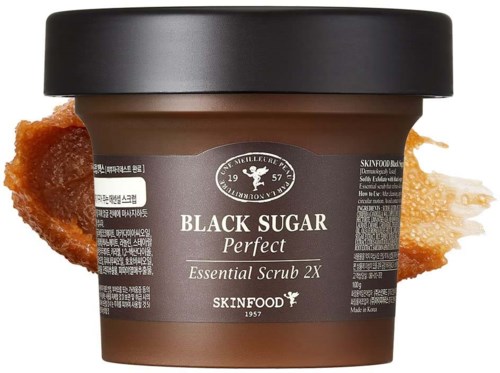 En burk Black Sugar Perfect Essential Scrub med några karamellbitar bredvid.