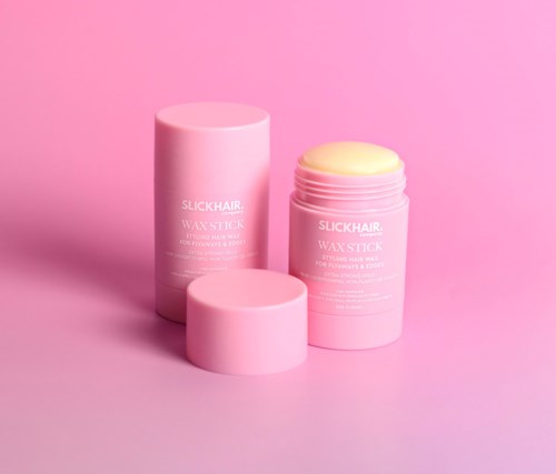 Zwei pinke Behälter für Wachsstick, einer offen mit gelbem Wachs, der andere geschlossen, auf pinkem Hintergrund.