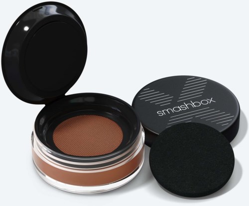En beholder med brun makeup, en svamp, en svart lokk med "smashbox" skrevet på, og en svart påføringspenn.