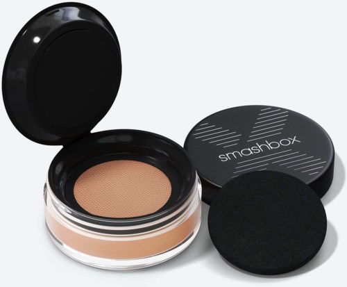 Een compact make-upproduct met een cushion foundation en zwarte spons, gelabeld 'smashbox.'