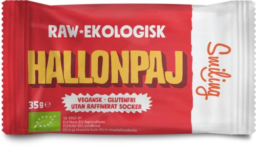 En liten, rød og hvit pose merket 'RAW- økologisk blåbærpai' med tekst som indikerer at den er vegansk, glutenfri og uten sukker.