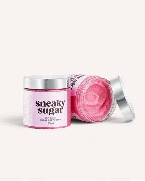 En rosa socker kroppsskrubb i liten burk med silverlock, märkt sneaky sugar med text och varumärke.