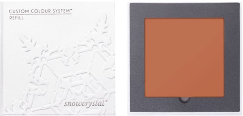 En sminkpalett med en ferskenfarget blush og en hvit bakgrunn med snøfnuggdesign.