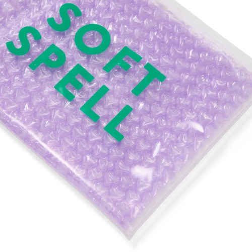 Eine lilafarbene Luftpolsterverpackung mit grüner Aufschrift "SOT SPÉL".