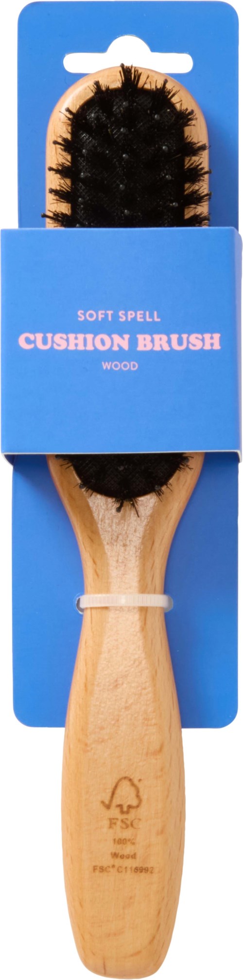 Valkoinen puukäsinen pehmustettuharja, jossa mustat harjat, sinisessä pakkauksessa lukee 'Soft Spell Cushion Brush.'