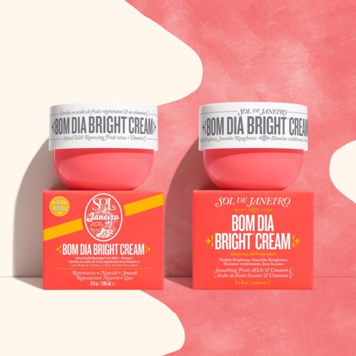 Kaksi vaaleanpunaisia Bom Dia Bright Cream -purkkeja samankaltaisissa vaaleanpunaisissa laatikoissa, valkoisilla ja keltaisilla tarroilla, leikkisän pinkin taustan edessä.