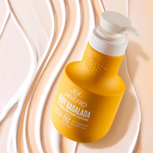 Yellow lotion bottle with white pump on a textured white background.