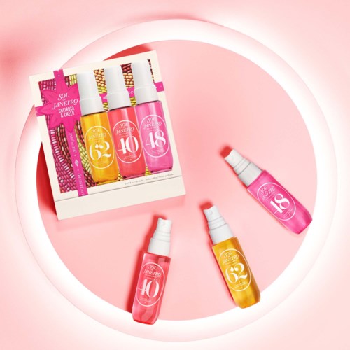 Ett set med tre färgglada nagellacksflaskor med olika nummer, placerade på en rosa bakgrund med en vit cirkel.