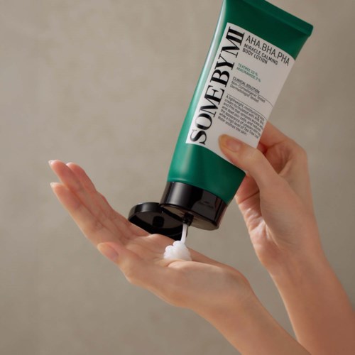 Groene tube lichaamslotion met zwarte dop, gelabeld zomergeur, wordt uitgedrukt.