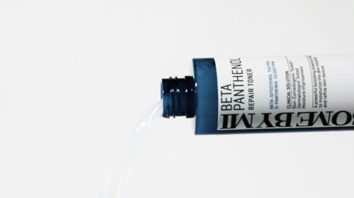 Eine Tube mit Hautcreme mit der Aufschrift 'Beta PATA ITHENOL' liegt seitlich mit etwas Creme heraus.