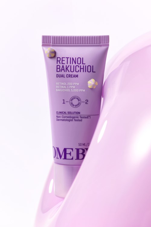 A tube of skincare cream labeled Retinol and Bakuchiol, with a purple and white design, partially surrounded by pink cream.