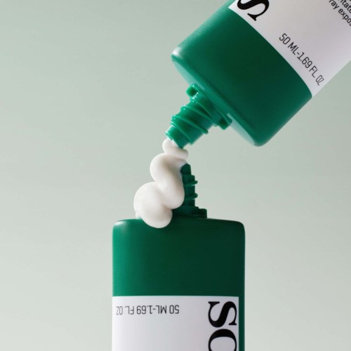 Groene huidverzorgingsfles die lotion in een andere fles met een groene dop giet.