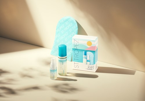 A skincare set with bottle, pump, and a box labeled "Purely" and "Sti Tropez" on a light surface.