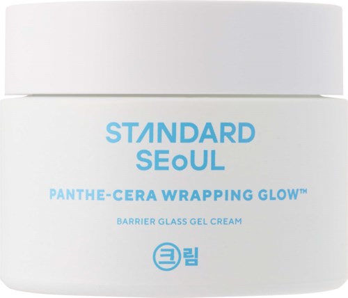 Ein weißer Behälter mit blauer Schrift zeigt ein Hautpflegeprodukt namens Standard Seoul Panthe-Cera Wrapping Glow.