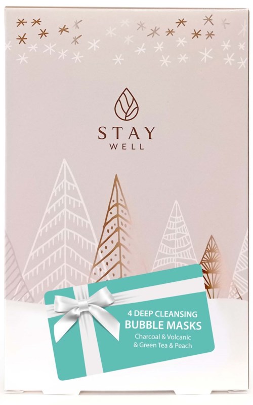 The box labeled 'Stay Well' with trees and snowflakes, and a gift tag for bubble masks with green tea and peach.