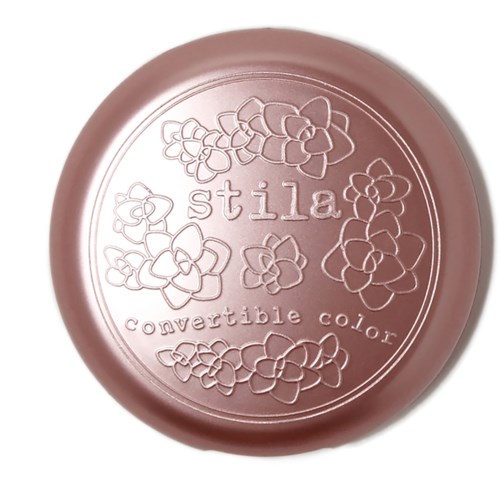 Pink round container with floral design and text that says 'stila' and 'convertible color.'