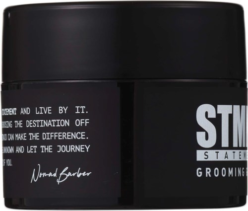 En sort grooming-beholder med hvid tekst og signatur, herunder ordene "Statement Grooming" og motiverende besked.