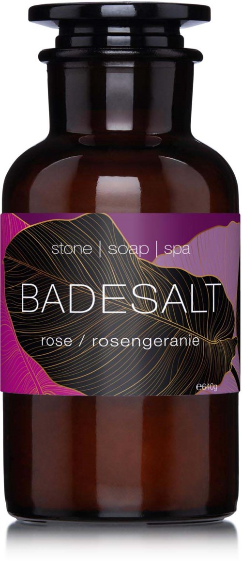 En brun flaske med en lilla etiket til rosenduftende bade-salt eller sæbe.