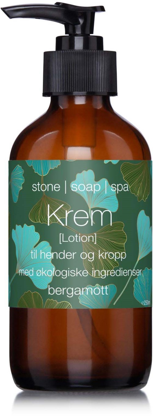 En brun flaske med pumpe, merket som krem for hender og kropp, med naturlige ingredienser som bergamott.