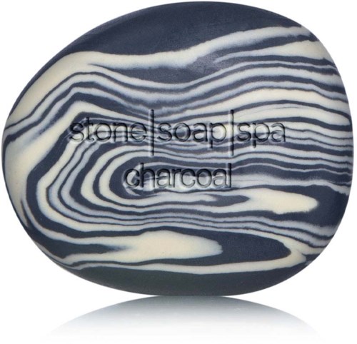 En rund tvål med svarta och vita randmönster, märkt 'stone soap spa charcoal'.