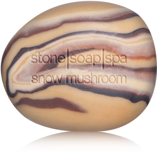 En slät sten med orden "stone soap spa snow mushroom" ingraverade i den, med beige, bruna och svarta strimmor.