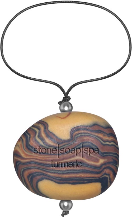 En sten med färgglada mönster och orden "stone | soap spa" och "turning" på, hängande i ett snöre.